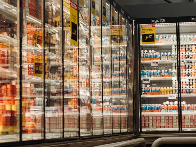 Meubles frigorifiques vitrés alignés dans un rayon de supermarché.