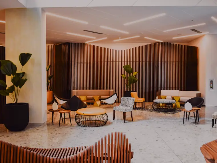 Hall d'hôtel contemporain, éclairage et climatisation en fonctionnement.